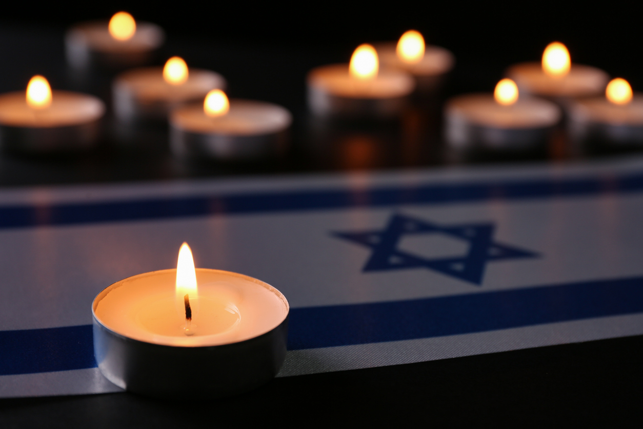 candles surrounding Israeli flag