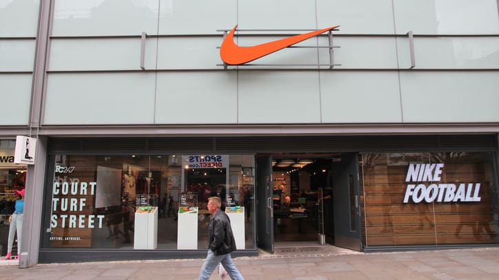 A woman walks past a nike store in london.