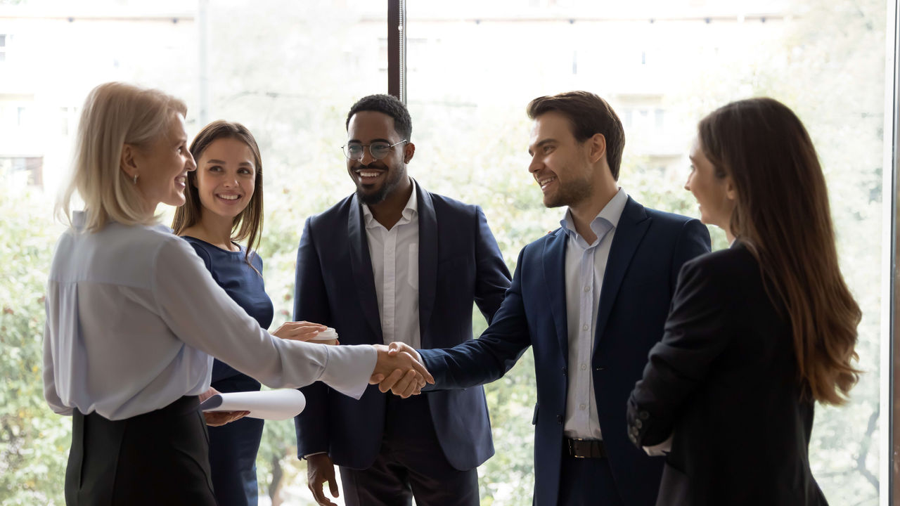 A group of business people shaking hands in an office.