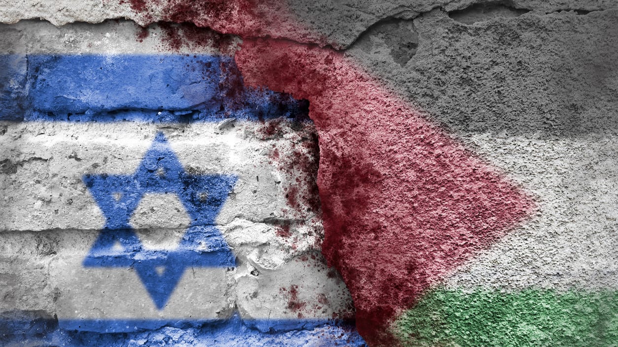 Israeli and palestinian flags painted on a brick wall.