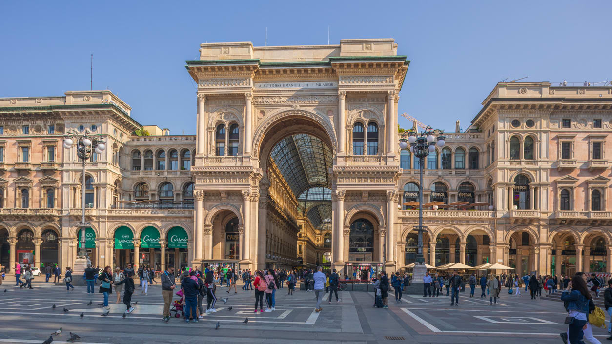 A square in milan, italy with many people walking around.