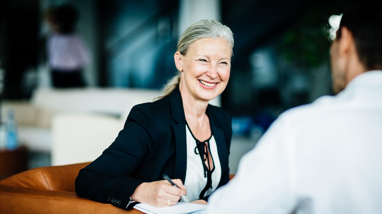 A woman is talking to a man in an office.