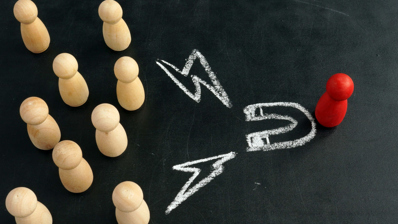 A group of wooden figures standing in front of a chalkboard.