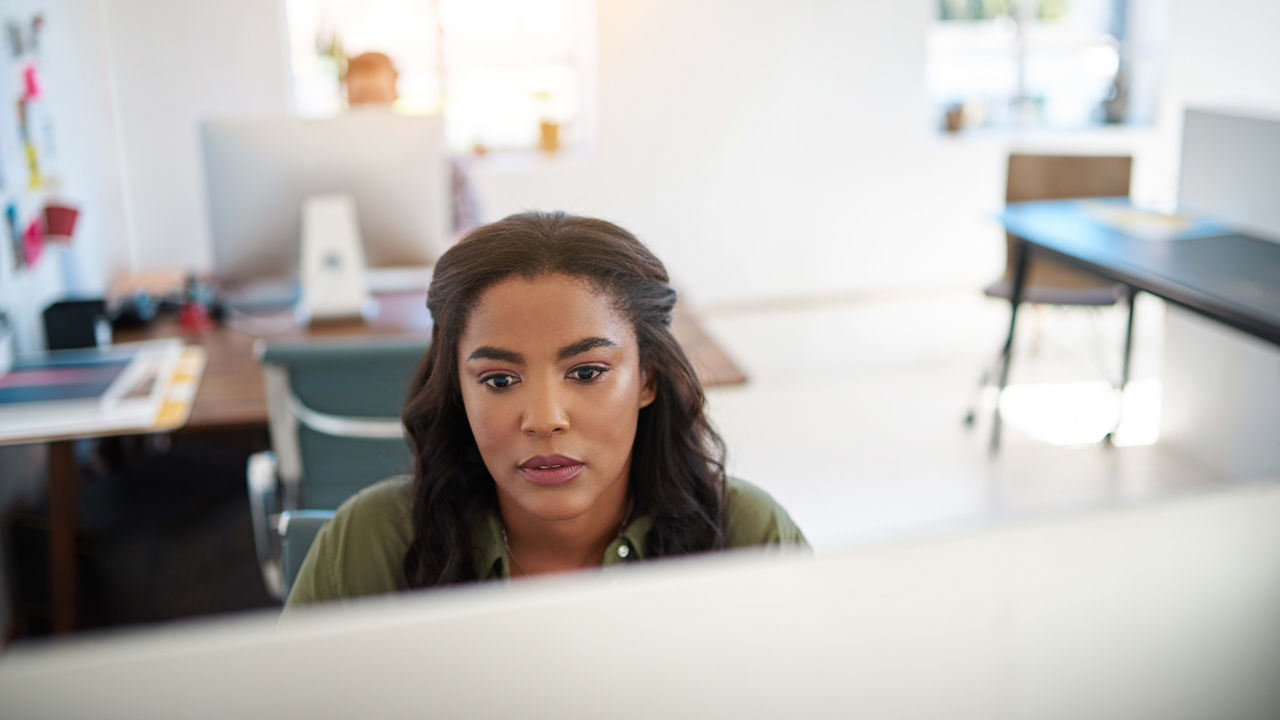 A woman sitting in front of a computer screen.