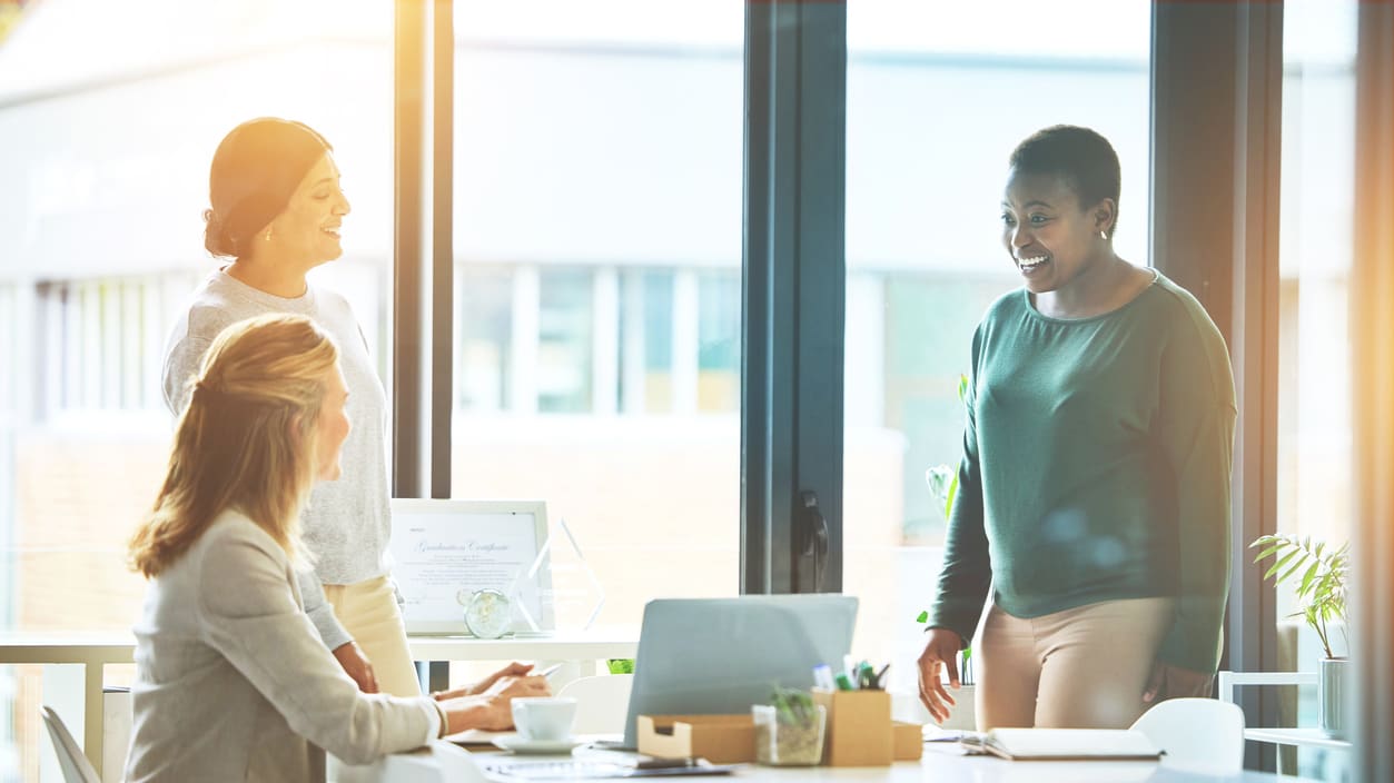 A group of women talking at a conference table.