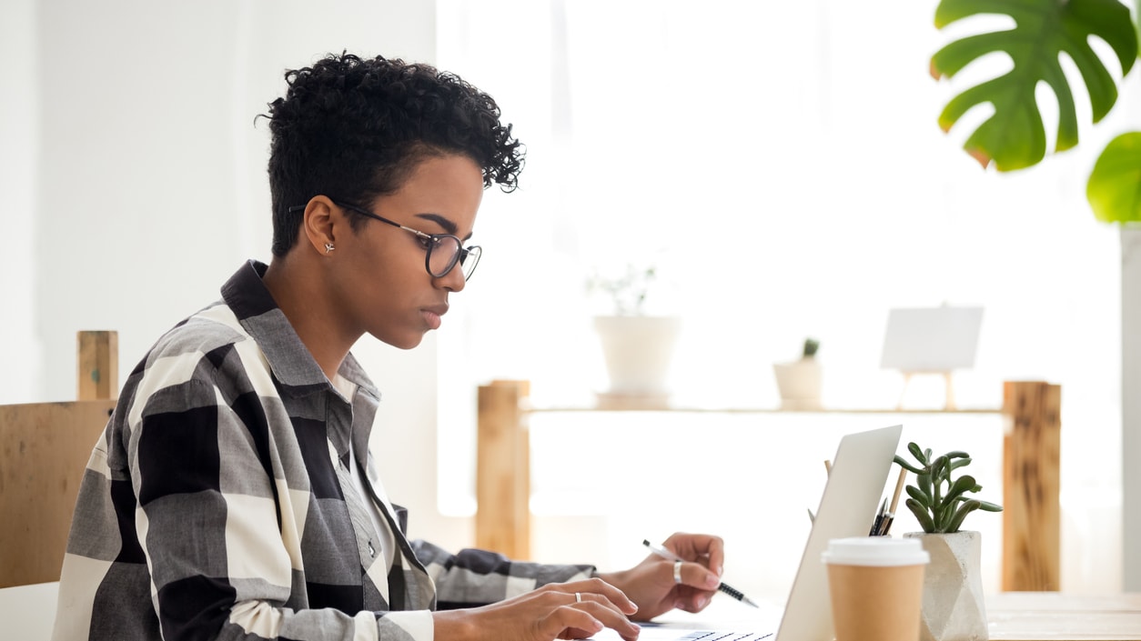 A woman working on a laptop in her home office.