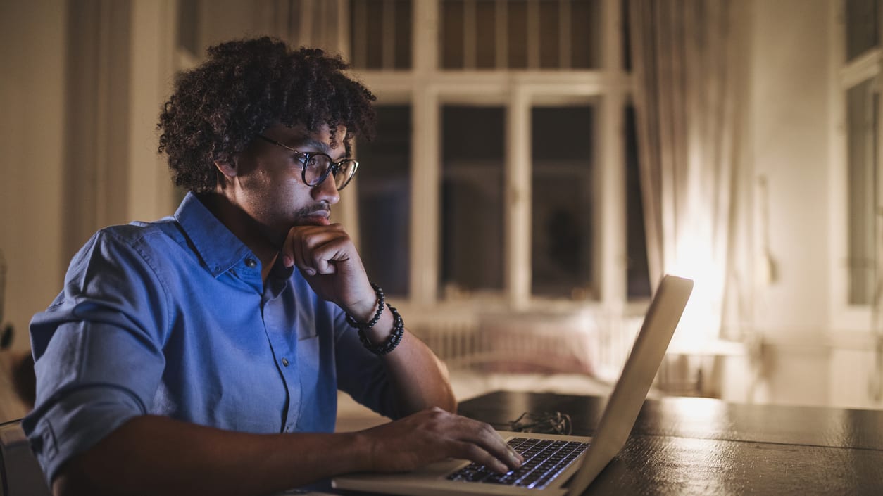 A man working on a laptop at night.