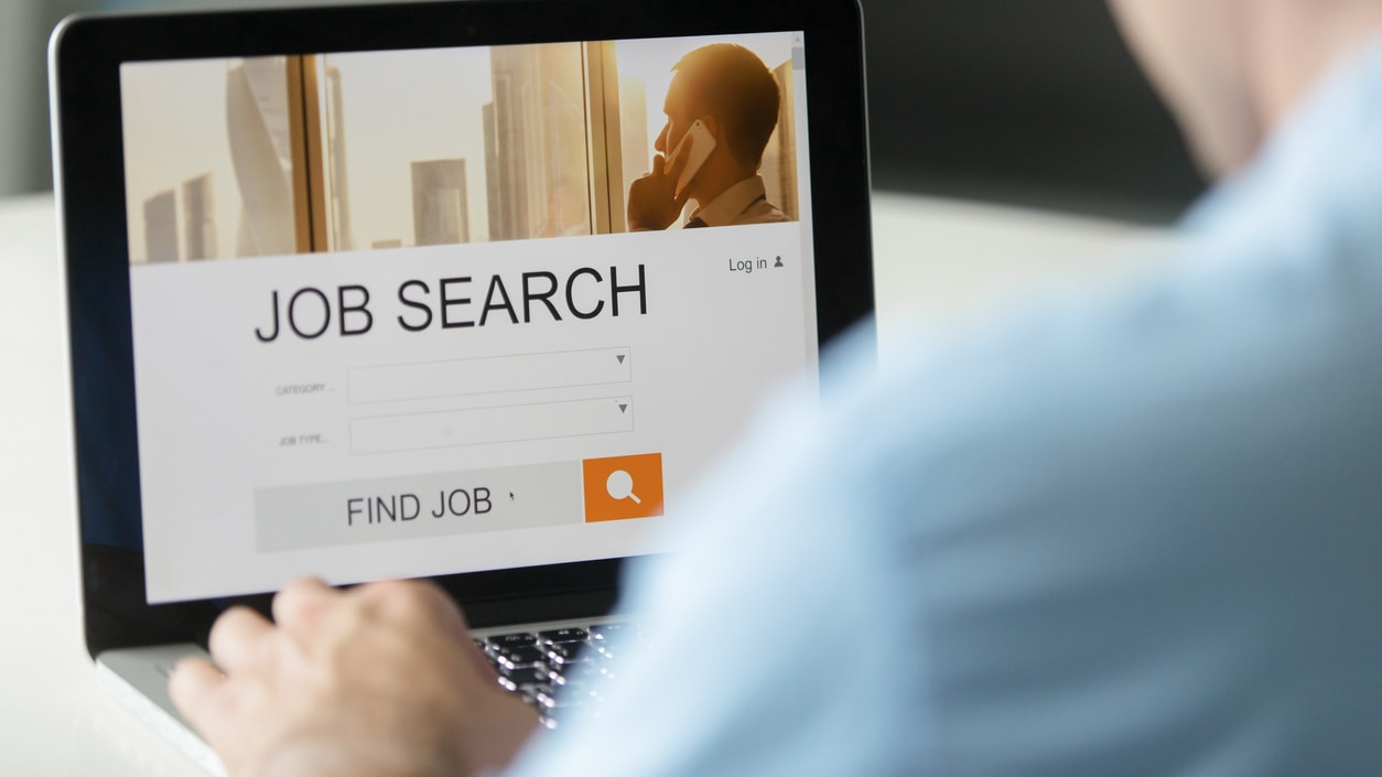 A man is using a laptop to search for a job.