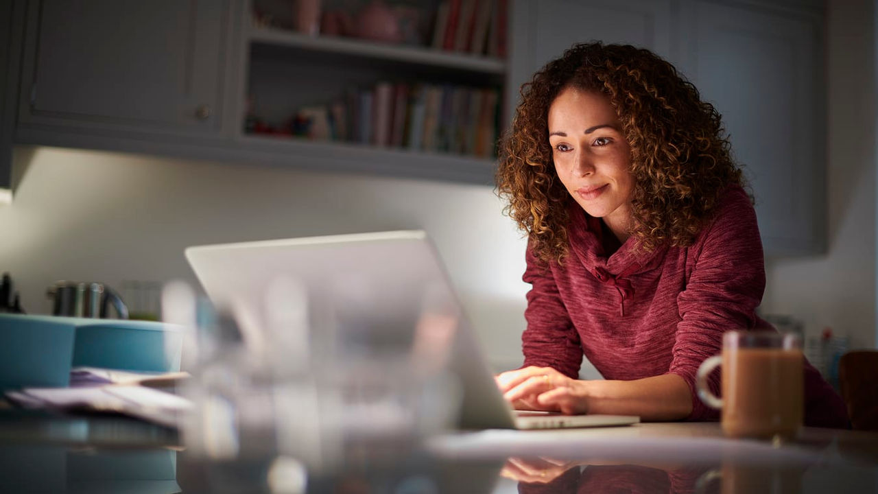 A woman working on her laptop at night.