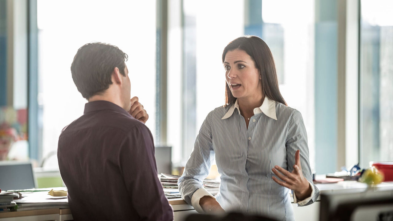 Two business people talking in an office.