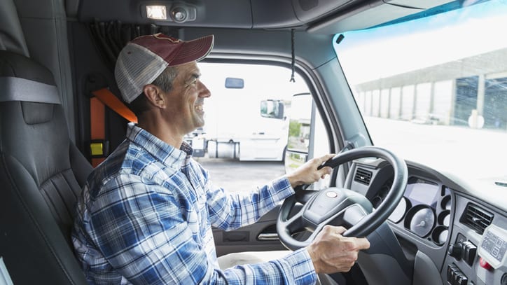 A man sitting in the driver's seat of a truck.