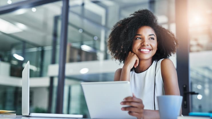 A young african american woman using a tablet computer in an office.