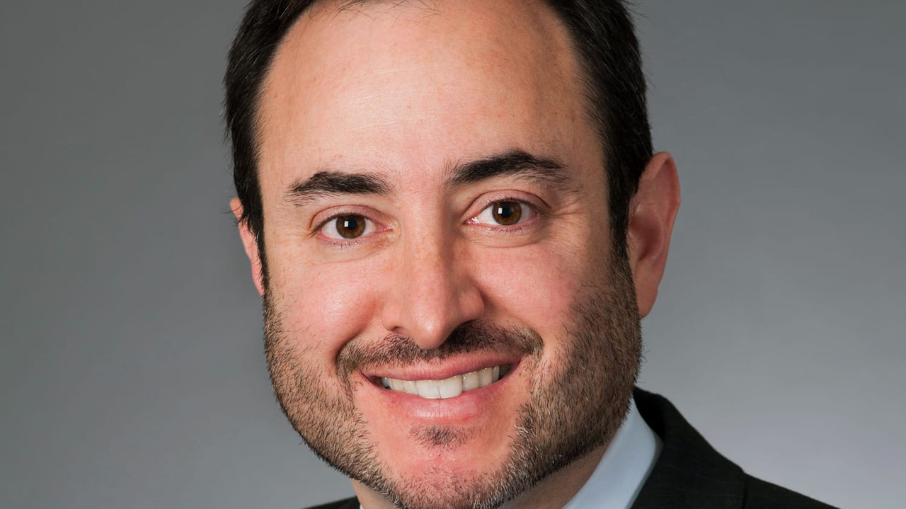 A man in a suit and tie smiling.