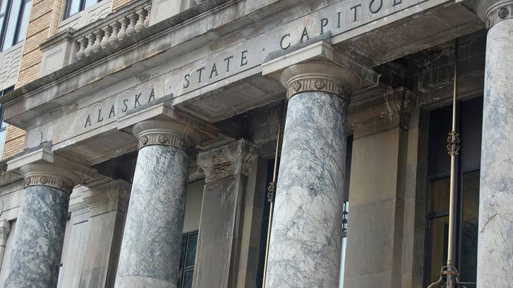 A building with columns and a sign that says alaska state capital.