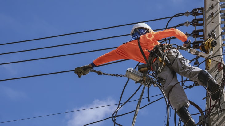 A man is working on a power line.