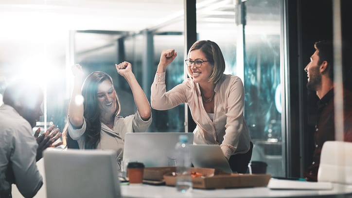 A group of business people celebrating in an office.