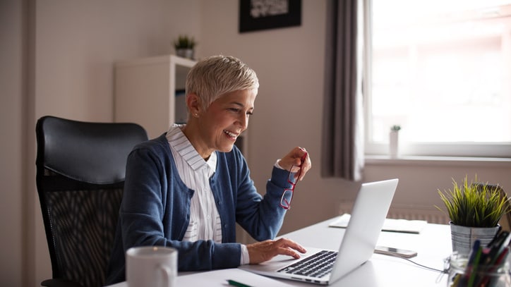 A woman sitting at a desk using a laptop.