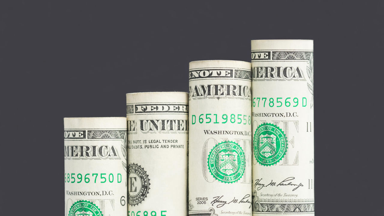 A stack of dollar bills on a black background.