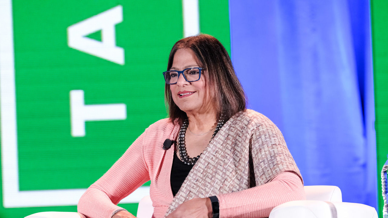 A woman sitting in a chair at a conference.