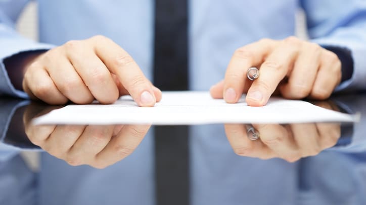 A businessman signing a piece of paper.