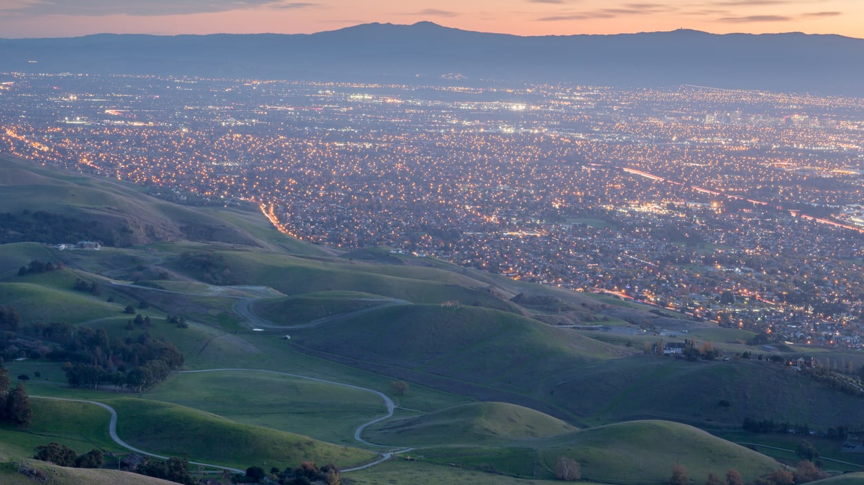 A city is seen from the top of a hill.