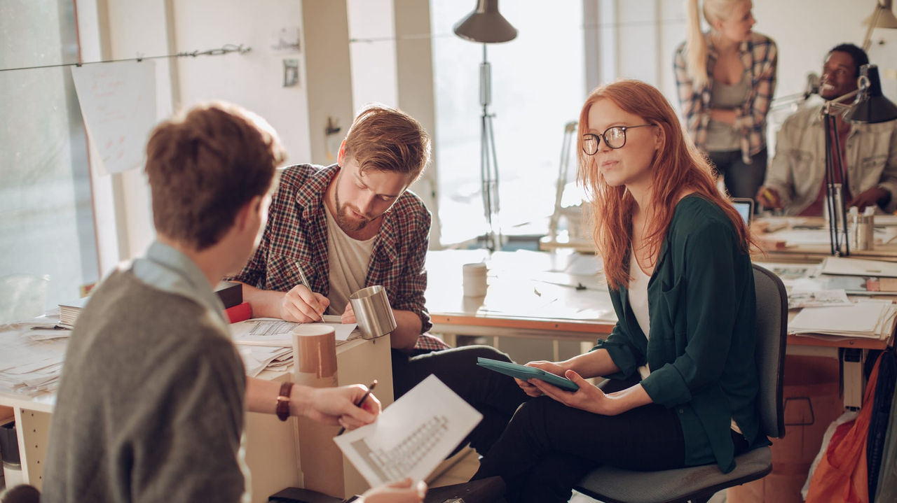 A group of people sitting around a table in an office.