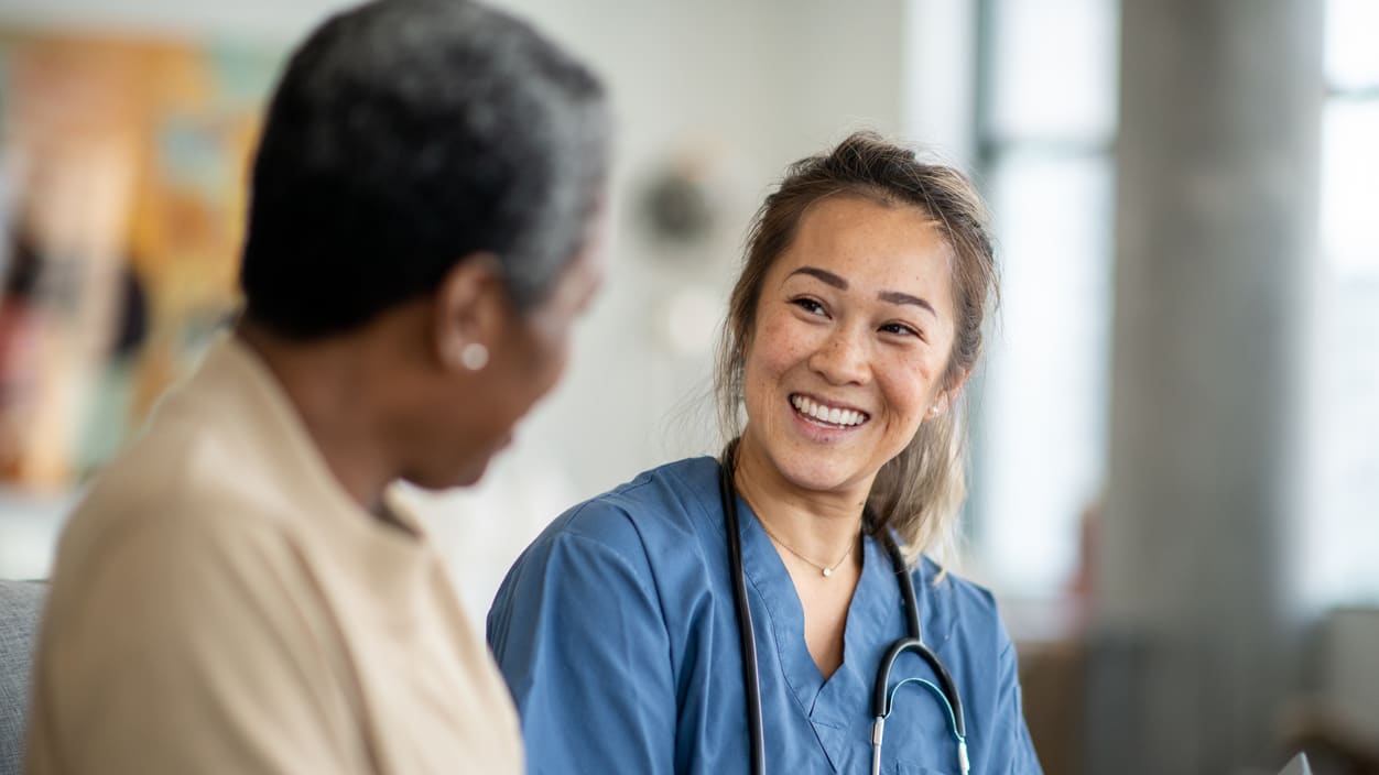 A nurse is talking to a patient in a hospital.