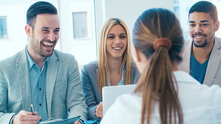 A group of business people having a conversation in an office.