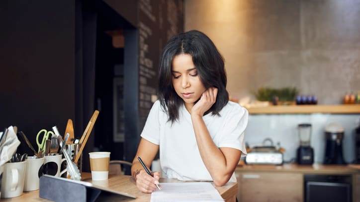 A woman is sitting at a table in a coffee shop.