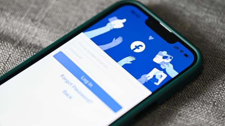 The facebook logo is displayed on a cell phone.