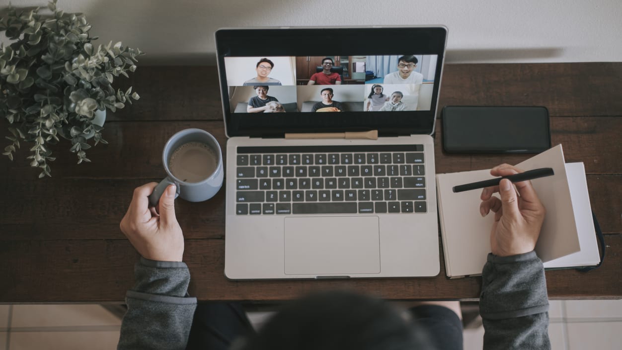 A person using a laptop and a cup of coffee.