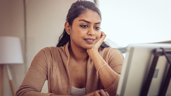 A woman sitting at a desk looking at her computer.