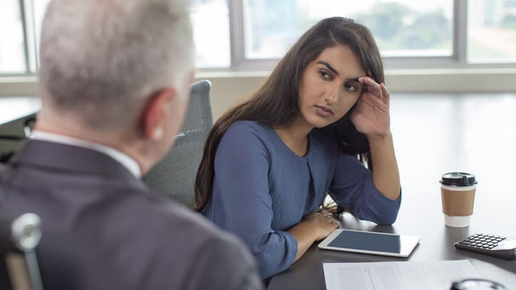 A woman is talking to a man in an office.