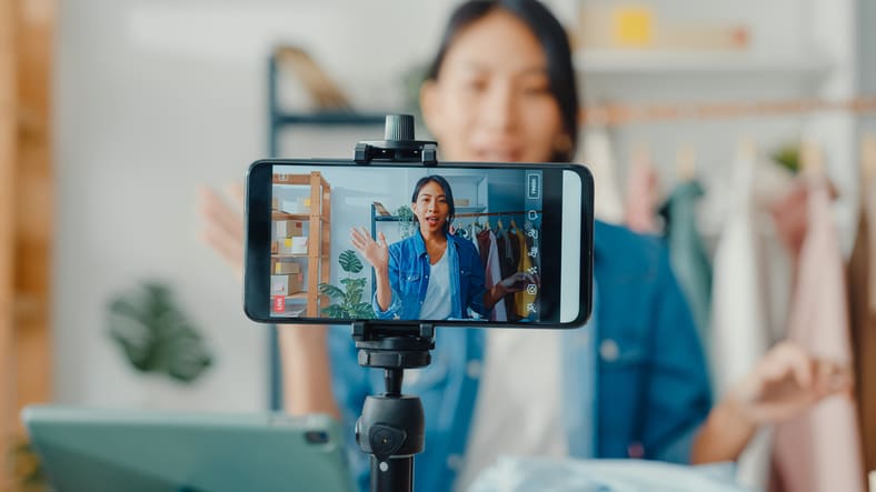 A woman is taking a video on her phone.