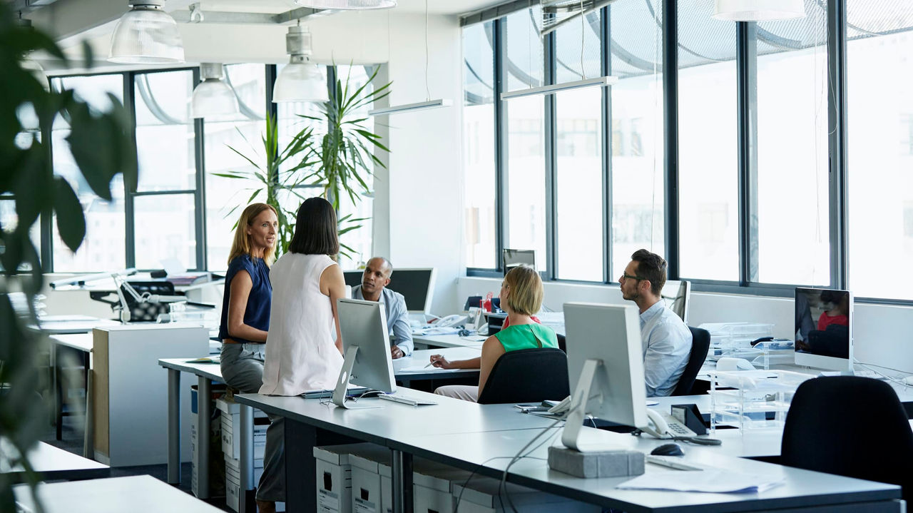 A group of people sitting at desks in an office.