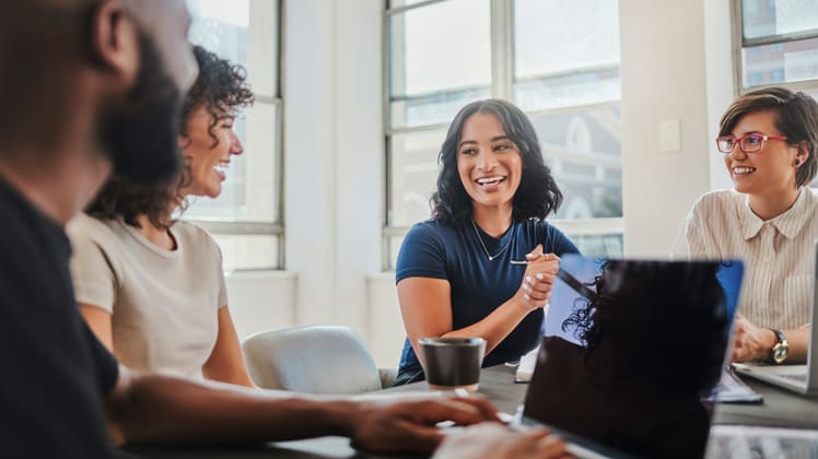 A group of people sitting around a table in an office.