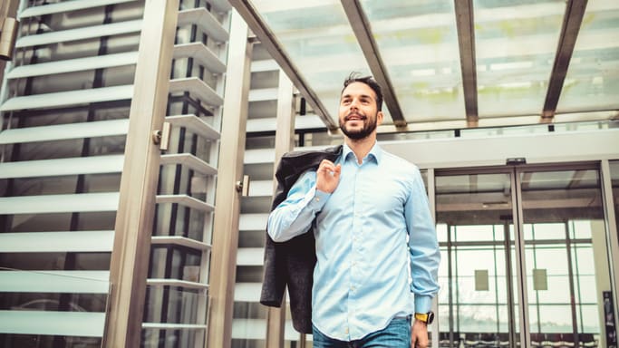 A businessman is walking through an office building.