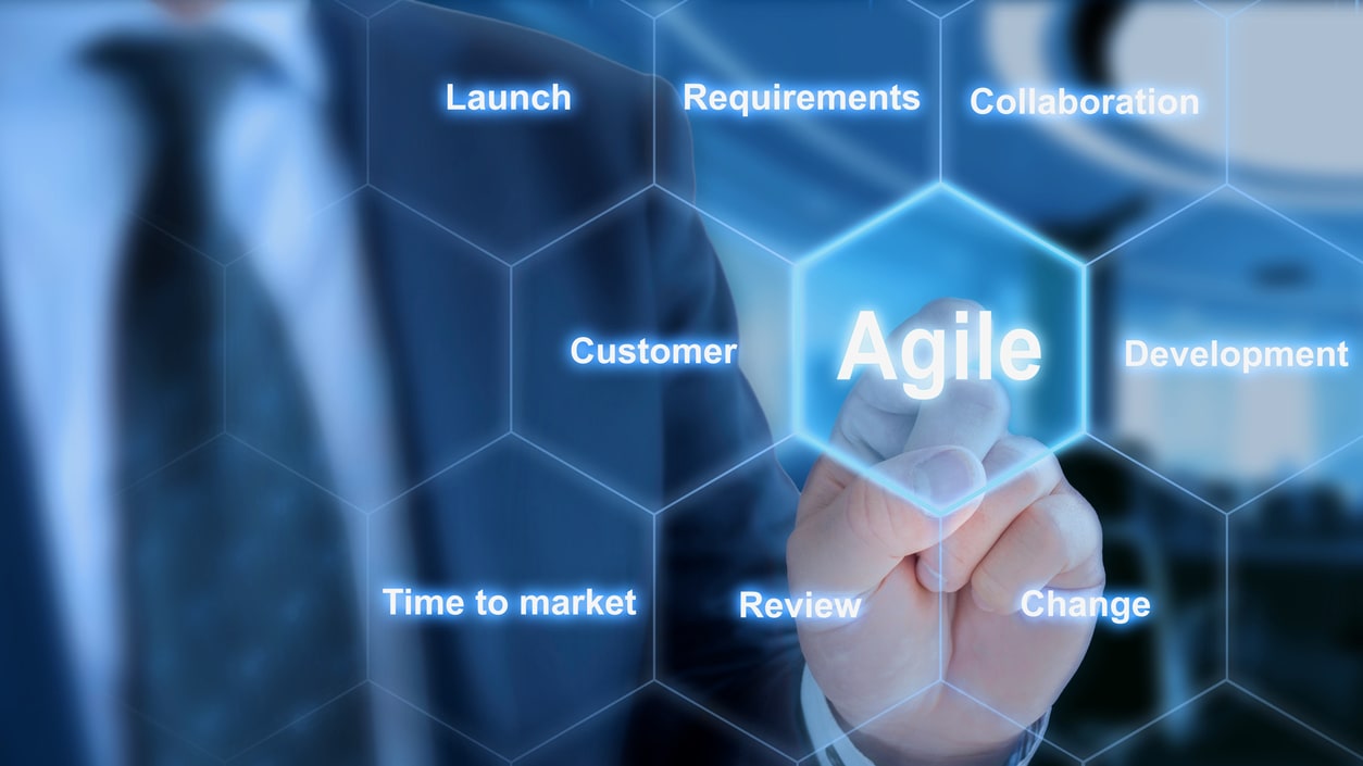 A businessman is pointing at the word agile.