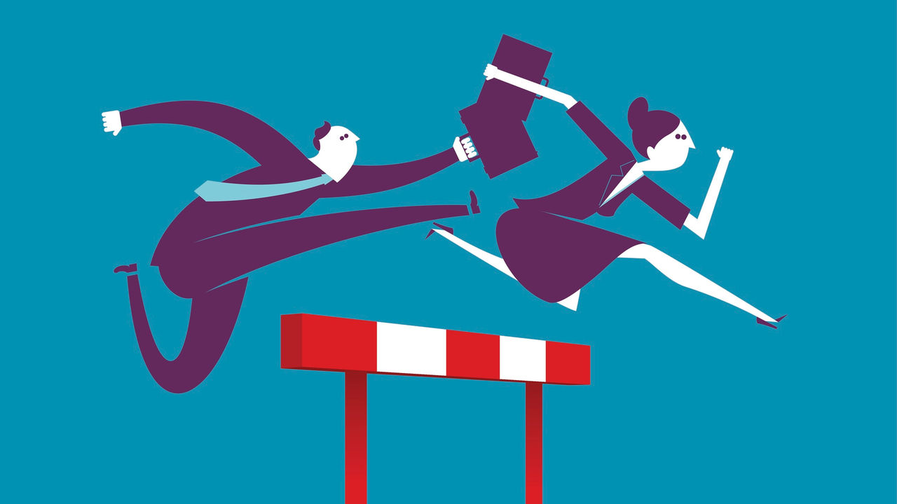 A businessman and woman are jumping over a hurdle.