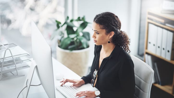 A woman working on a computer in an office.