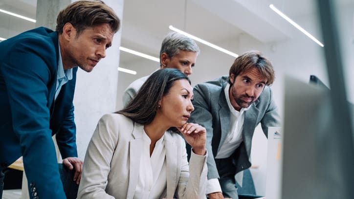 A group of business people looking at a computer screen.