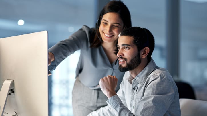 Two people looking at a computer screen.