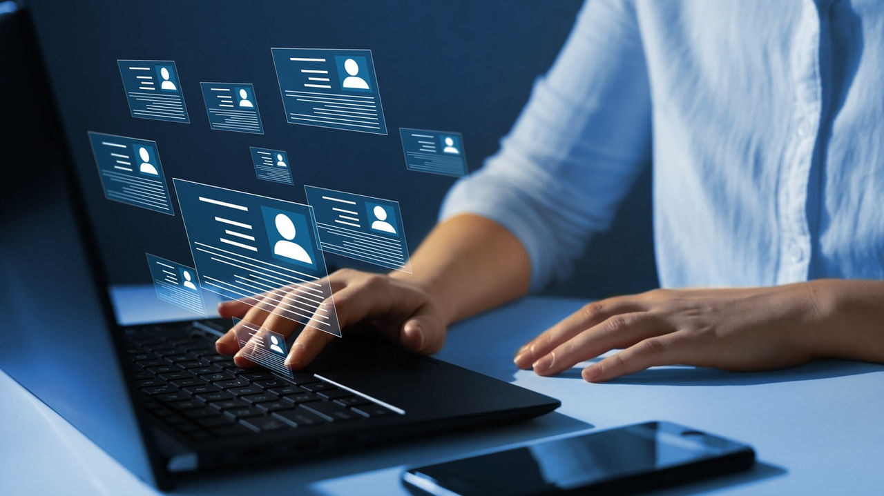 A woman is using a laptop with social media icons on it.