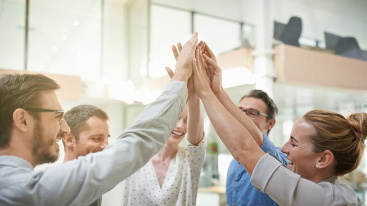 A group of business people giving each other high fives.