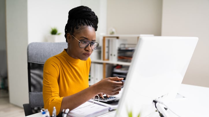 A woman working on her computer in an office.