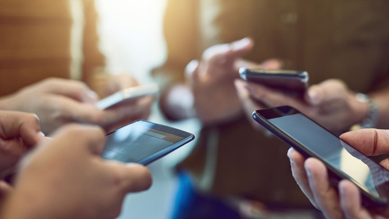 A group of people holding cell phones together.