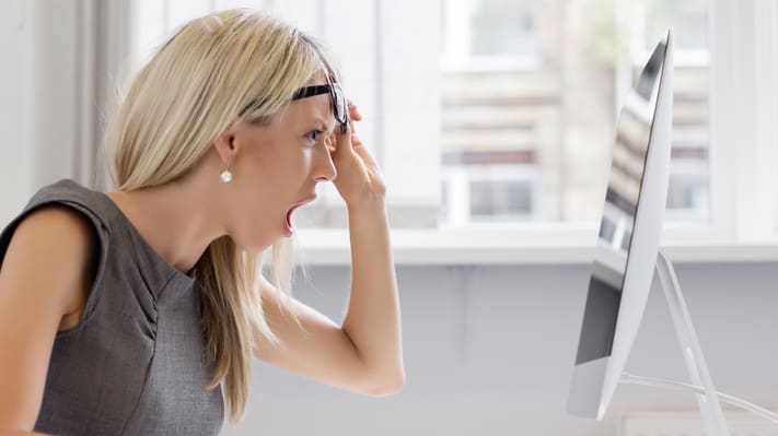 A woman is yelling at her computer screen.