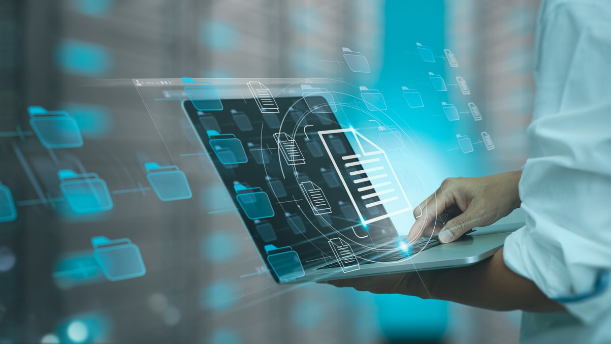 A person using a laptop in a data center.