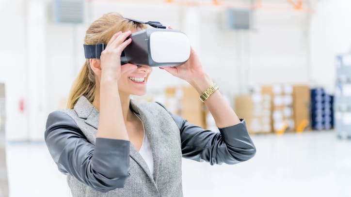 A business woman wearing a virtual reality headset in a warehouse.