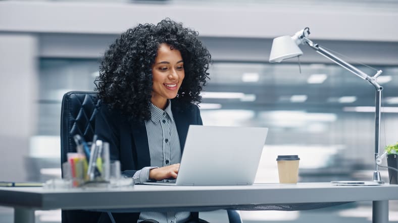 A businesswoman working on a laptop in an office.